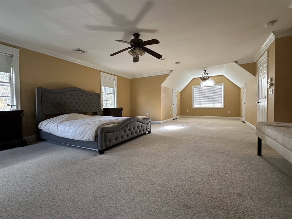 7 Rising Corner Road Southwick, MA 01077 - Photo 19 of 42 a spacious bedroom with a bed a window and a chandelier