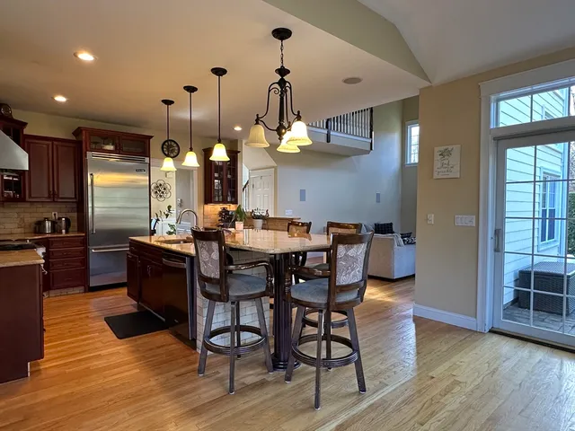 a dining room filled chandelier and wooden floor