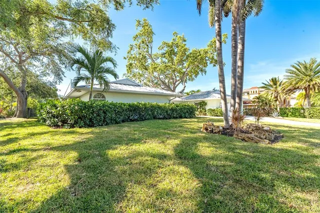 a view of a house with a yard and potted plants