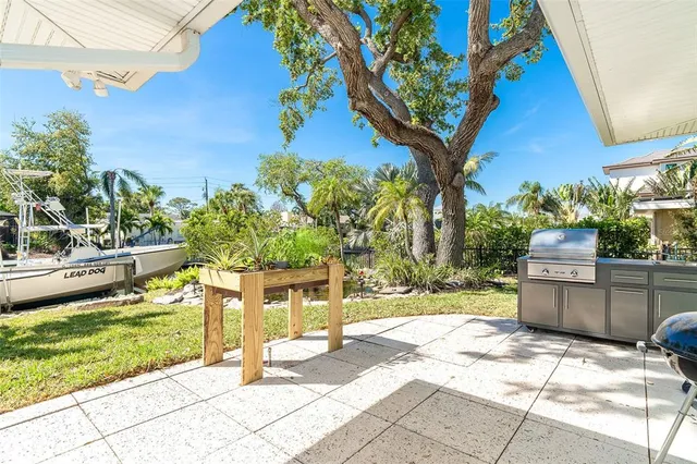 a backyard of a house with table and chairs under an umbrella