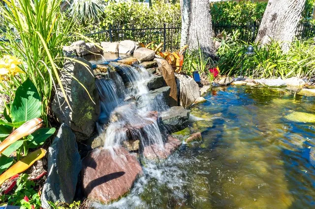 a patio with table and chairs and potted plants