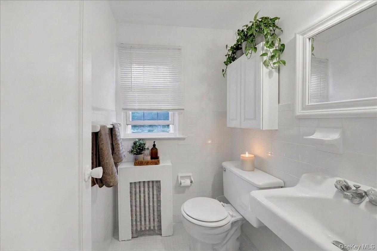 10 Susquehanna Road Ossining, NY 10562 - Photo 18 of 31 2nd floor half bathroom featuring white tile flooring, white subway tile wall surround, and a compact window with blinds