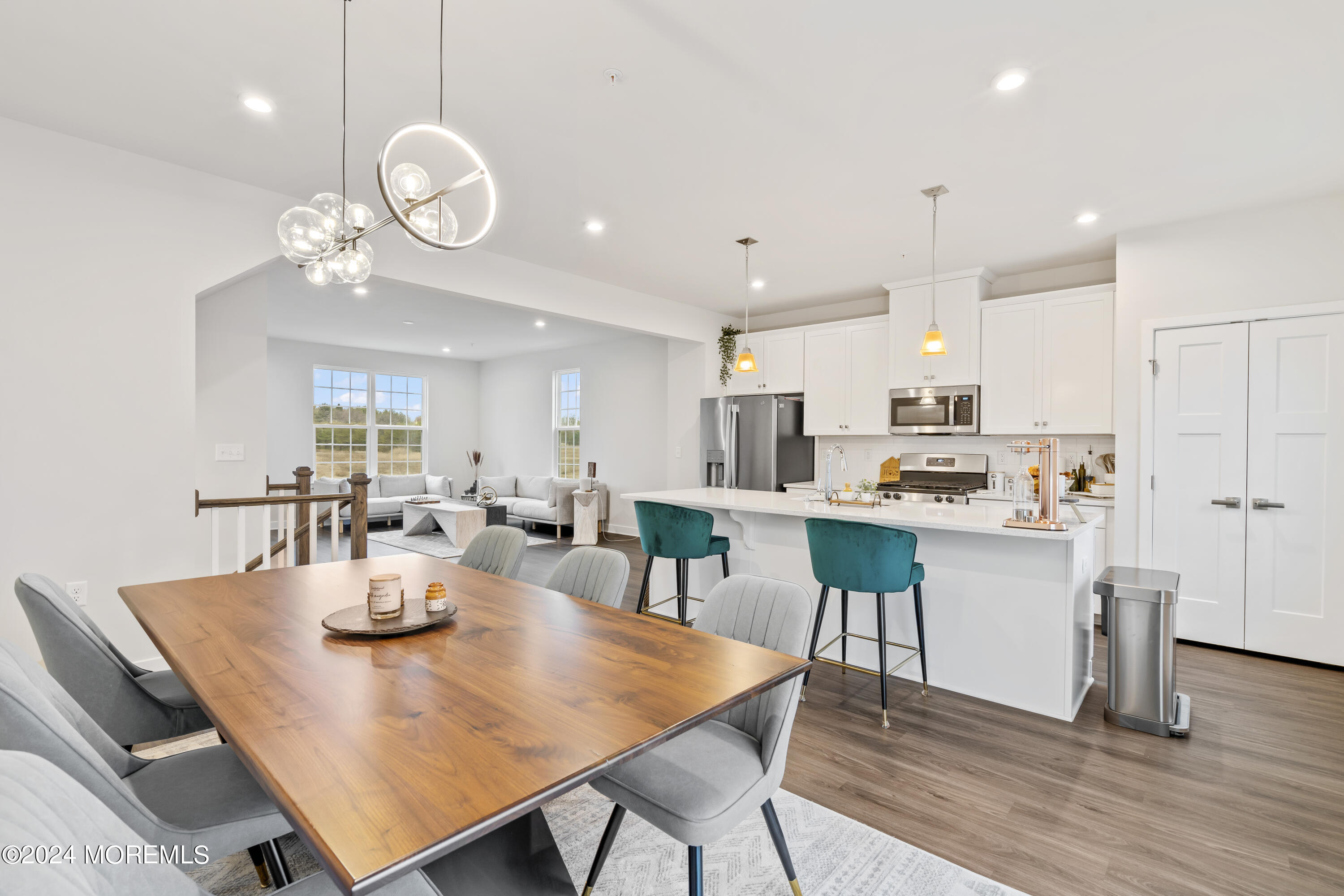 83 Anchor Way Cliffwood, NJ 07721 - Photo 8 of 27 a open dining room with stainless steel appliances kitchen island granite countertop a table chairs and a refrigerator