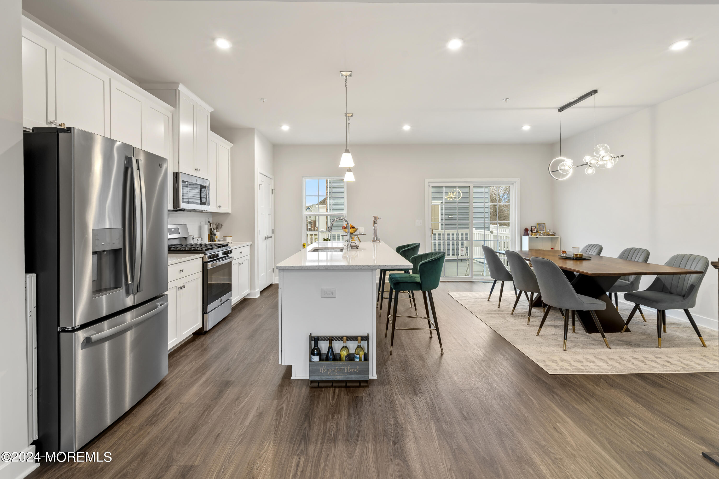 83 Anchor Way Cliffwood, NJ 07721 - Photo 9 of 27 a kitchen with stainless steel appliances a dining table chairs stove refrigerator and wooden floor
