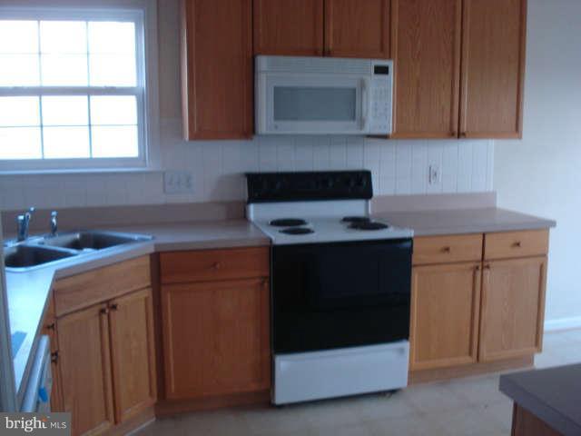 104 Limited Drive Ranson, WV 25438 - Photo 5 of 13 a kitchen with stainless steel appliances granite countertop a stove a microwave and a white cabinets