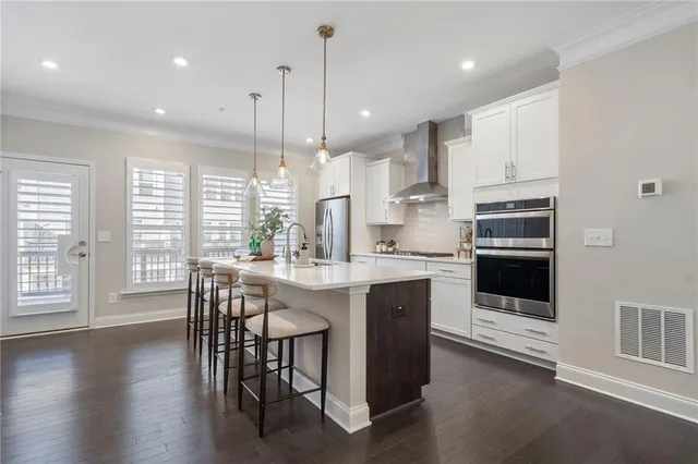 a kitchen with stainless steel appliances granite countertop a stove a sink a oven a dining table and chairs