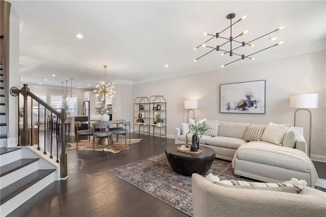 a living room with furniture a chandelier and a floor to ceiling window