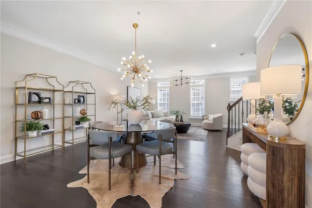 a view of a dining room with furniture a chandelier and wooden floor