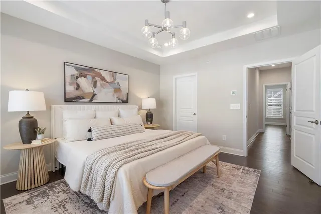 a bedroom with a large bed and a chandelier