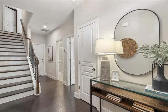 wooden floor with a potted plant on a table and chairs