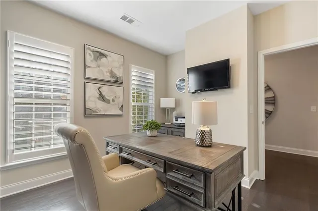 a living room with furniture a flat screen tv and windows
