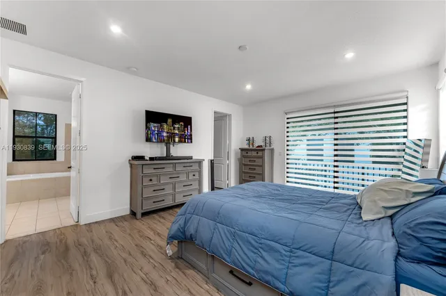 a bedroom with a bed and furniture with a bookshelf