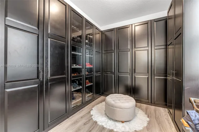 a bathroom with a refrigerator and a glass shower door