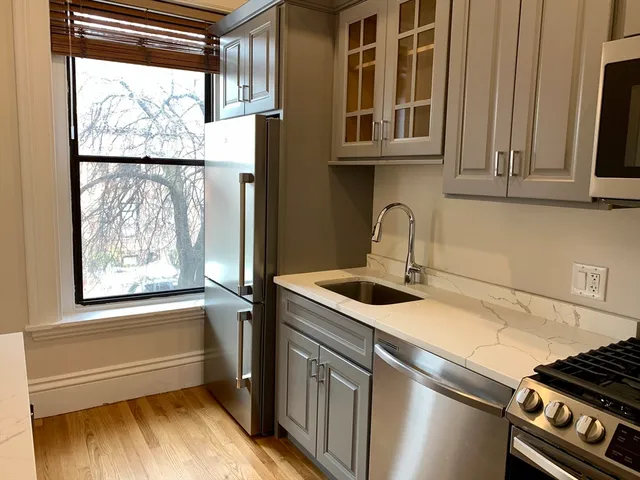 a kitchen with stainless steel appliances granite countertop a sink and a window