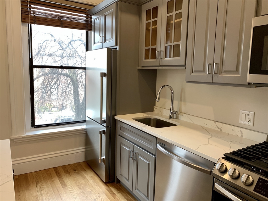 354 Marlborough Street, Unit 2 Boston, MA 02115 - Photo 3 of 10 a kitchen with stainless steel appliances granite countertop a sink and a window