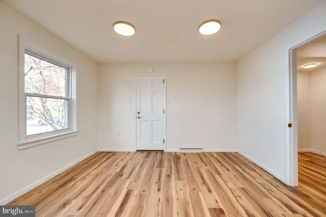 a view of empty room with wooden floor and fireplace