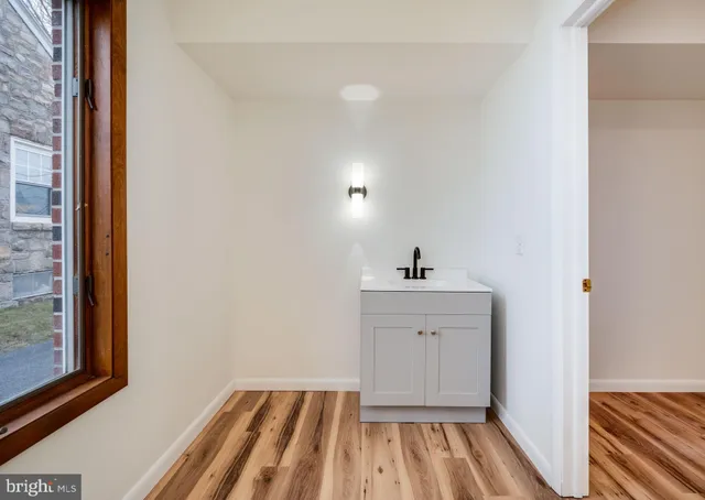 a view of empty room with window and wooden floor