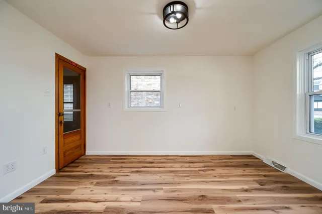 a view of a room with wooden floor and white walls