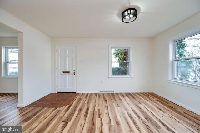 a view of empty room with window and wooden floor
