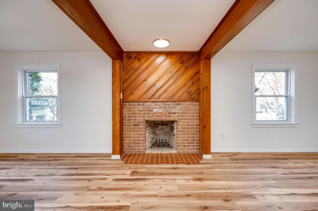 a view of empty room with wooden floor and fireplace