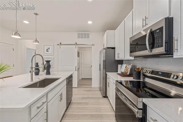 a kitchen with stainless steel appliances granite countertop a sink stove and refrigerator