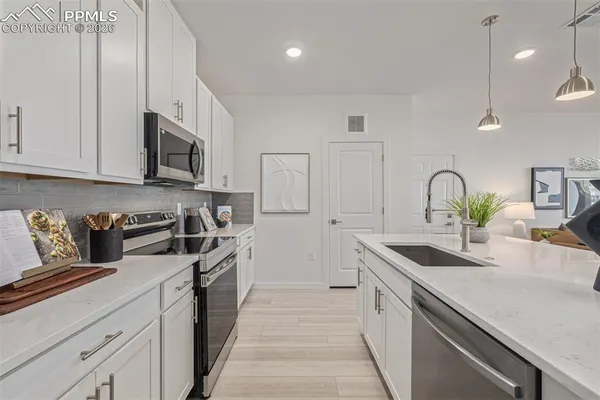 a kitchen with stainless steel appliances granite countertop a sink stove and cabinets
