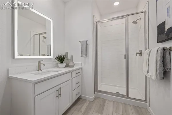 a bathroom with a shower sink and mirror