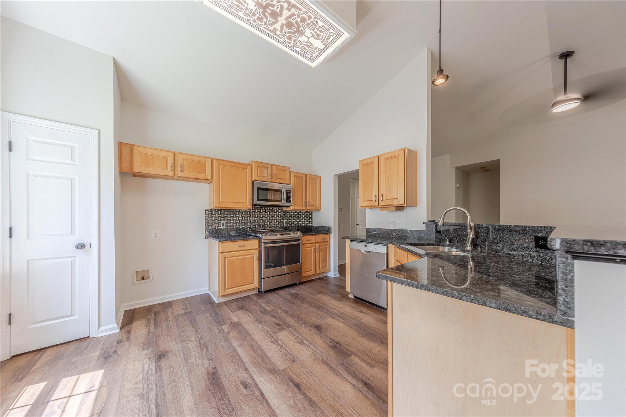 901 Clearbrook Road Matthews, NC 28105 - Photo 11 of 37 a kitchen with stainless steel appliances granite countertop a sink dishwasher stove and refrigerator with wooden floor