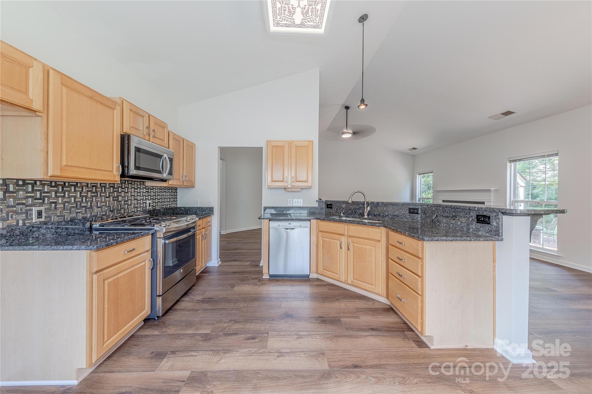 901 Clearbrook Road Matthews, NC 28105 - Photo 12 of 37 a large kitchen with granite countertop a stove top oven a sink a counter space and cabinets