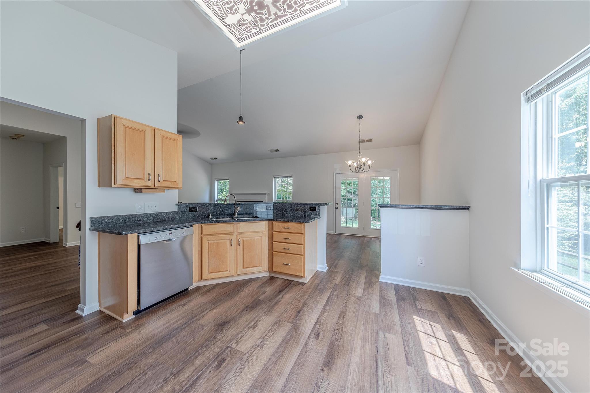 901 Clearbrook Road Matthews, NC 28105 - Photo 13 of 37 a kitchen with stainless steel appliances granite countertop a stove a sink and white cabinets with wooden floor