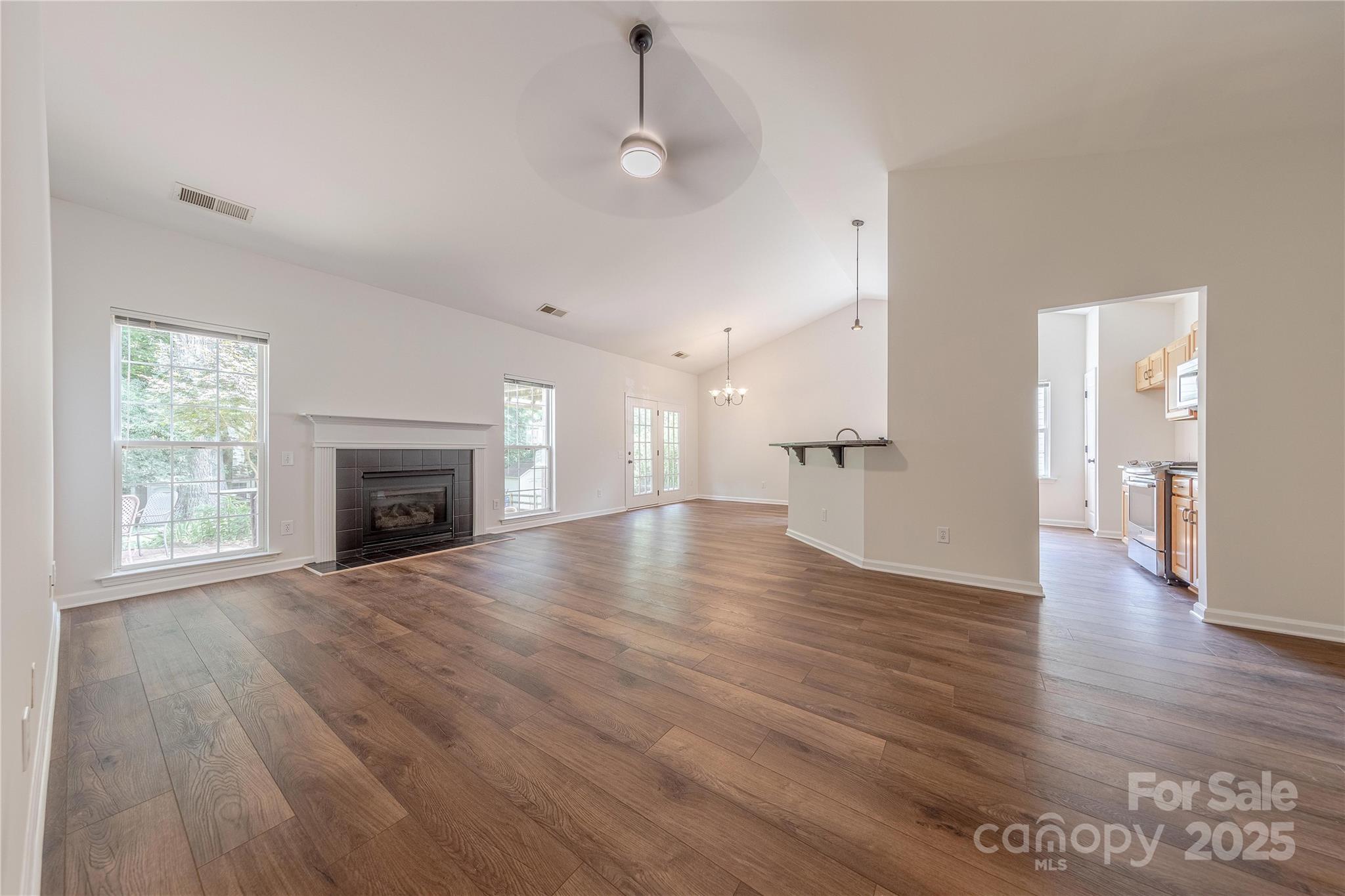 901 Clearbrook Road Matthews, NC 28105 - Photo 5 of 37 a view of an empty room with wooden floor and a fireplace