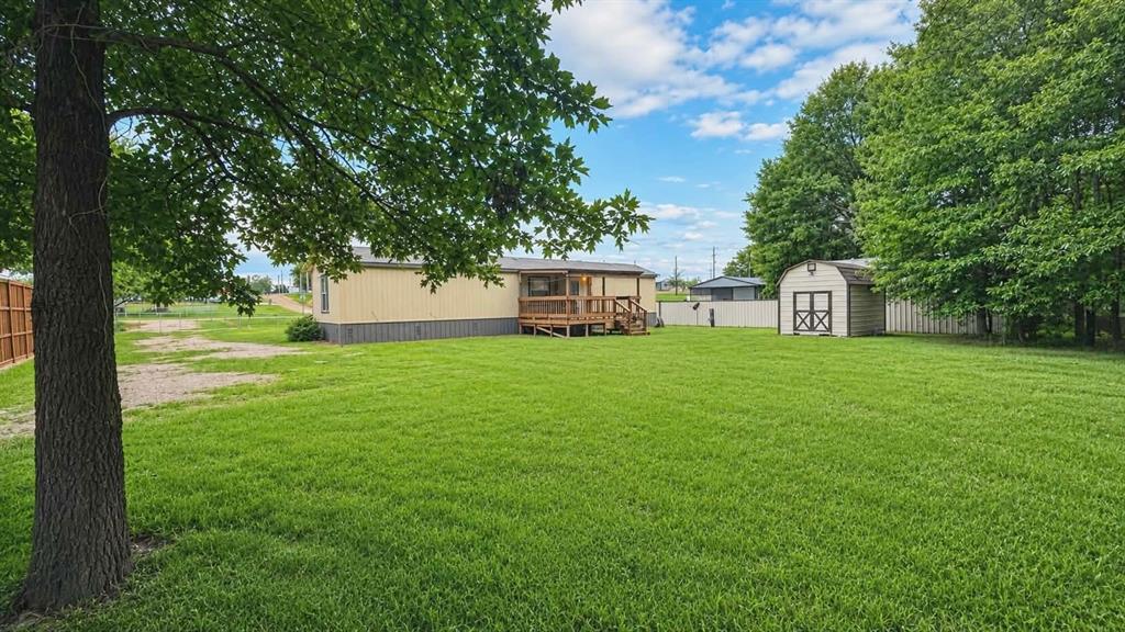 741 Waterfront Row Quitman, TX 75783 - Photo 28 of 40 a view of a white house in front of a big yard with large trees