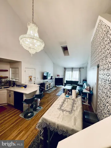 a living room with furniture kitchen view and a chandelier
