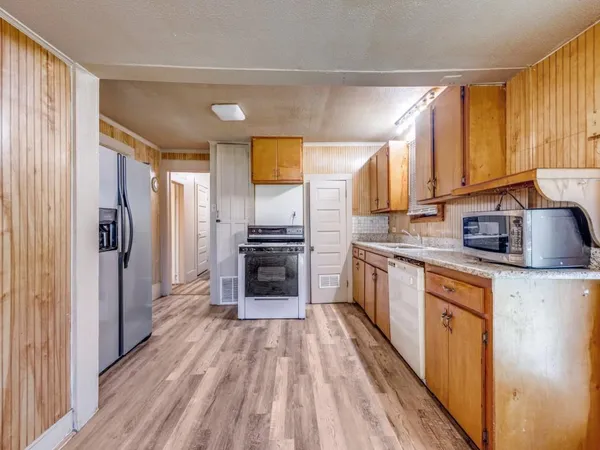 a kitchen with stainless steel appliances a refrigerator sink and cabinets