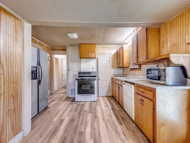 a kitchen with stainless steel appliances a refrigerator sink and cabinets
