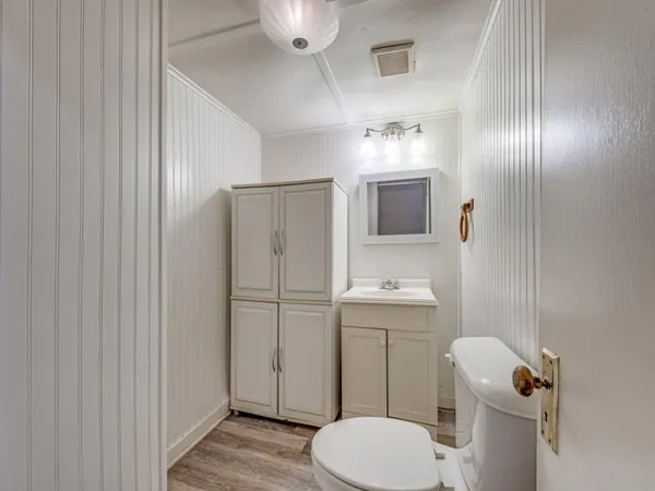 a bathroom with a toilet a sink and mirror