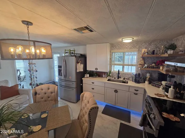 a kitchen with refrigerator a sink and chairs