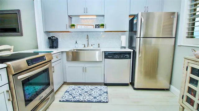 a kitchen with stainless steel appliances a refrigerator stove and sink