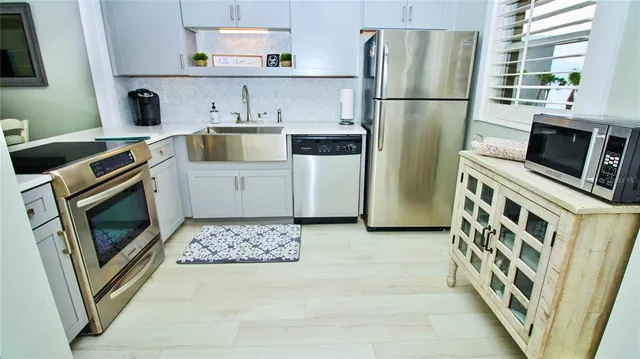a kitchen with stainless steel appliances a stove microwave and refrigerator