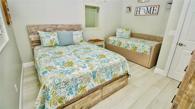 a bedroom with a bed and wooden floor