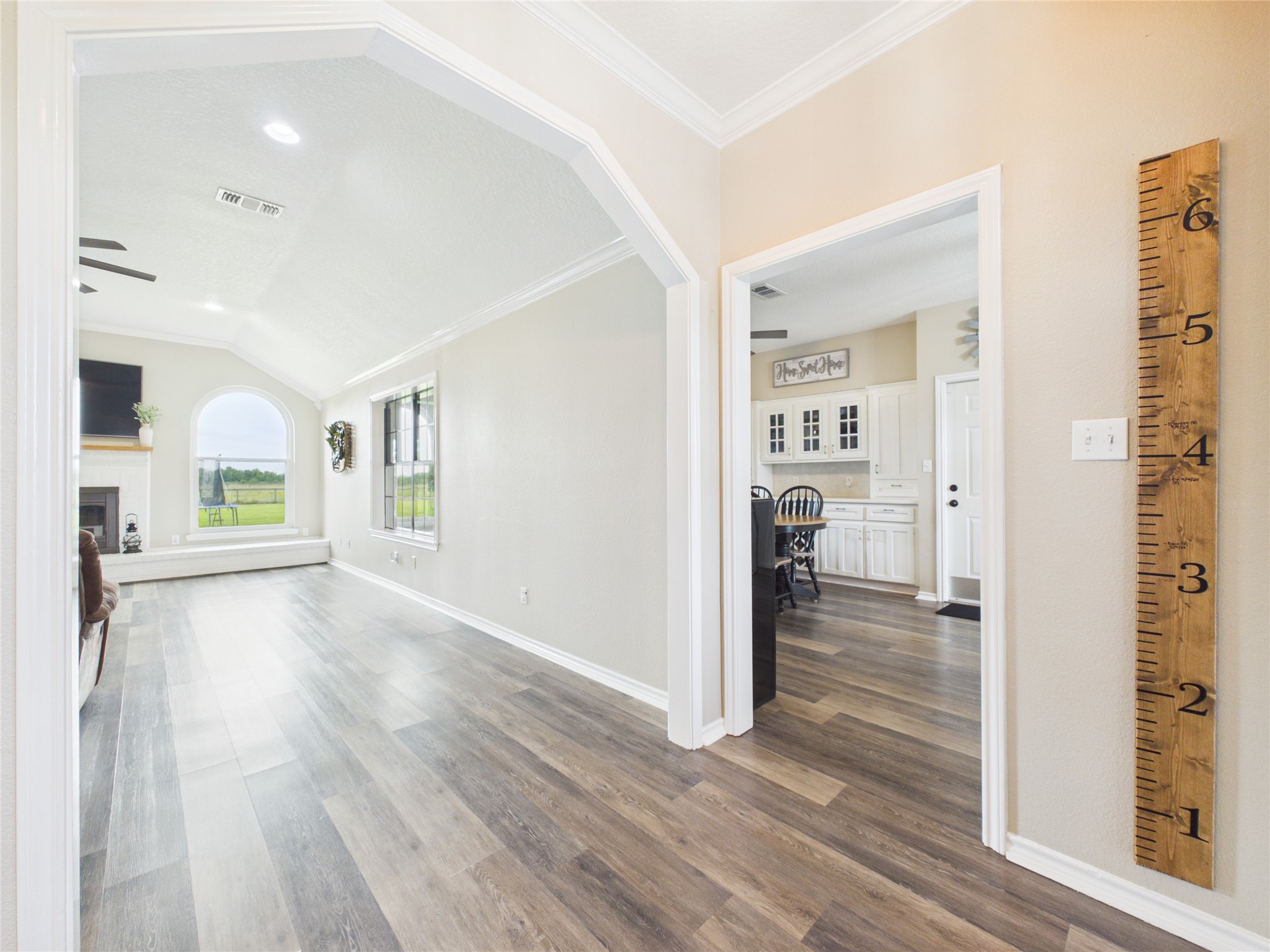 4610 Mustang Road Alvin, TX 77511 - Photo 10 of 50 Large cased opening into the heart of the home...the family room that features a wood burning fireplace centered on the back wall with two picture windows overlooking the back yard area. To the right is the kitchen, dining room and sun/play room.
