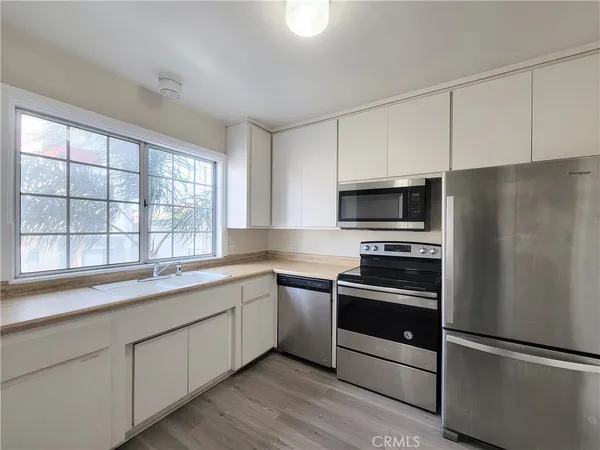 a kitchen with a sink stainless steel appliances and window
