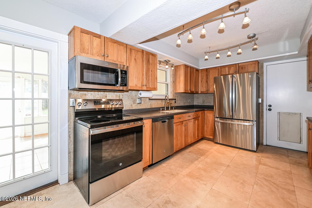 1077 Kings Road Neptune Beach, FL 32266 - Photo 2 of 19 a kitchen with stainless steel appliances granite countertop a stove a sink dishwasher a refrigerator and a microwave oven