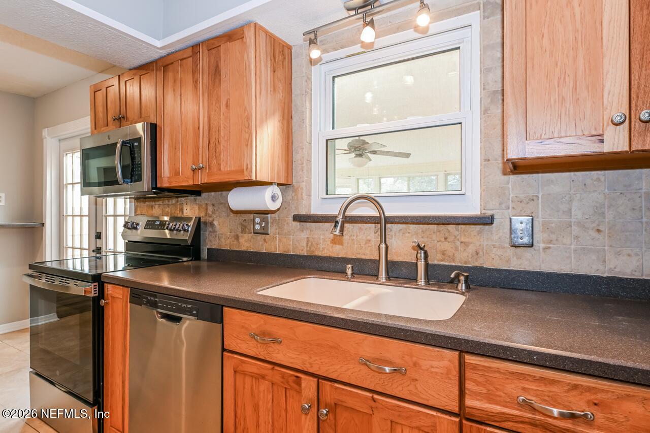 1077 Kings Road Neptune Beach, FL 32266 - Photo 3 of 19 a kitchen with stainless steel appliances sink a microwave and cabinets
