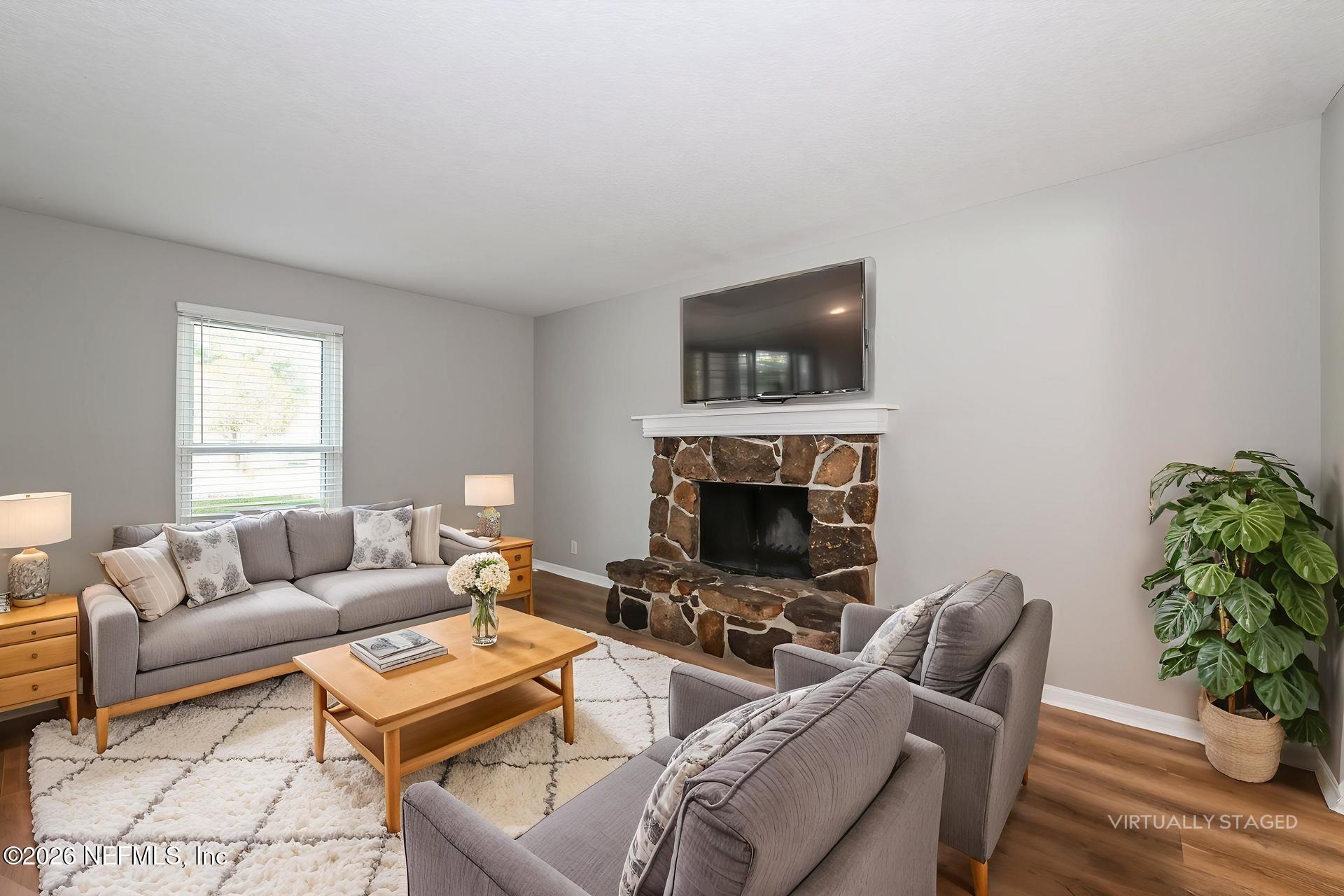 1077 Kings Road Neptune Beach, FL 32266 - Photo 6 of 19 a living room with furniture a fireplace and a potted plant