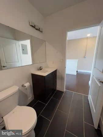 a bathroom with a toilet a sink a vanity and mirror