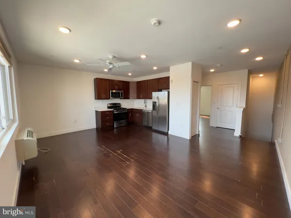 a view of kitchen with refrigerator stove and wooden floor