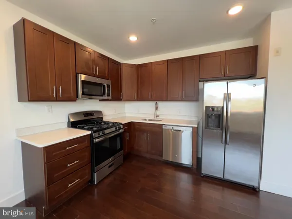 a kitchen with granite countertop wooden cabinets stainless steel appliances and a window