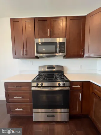 a kitchen with wooden cabinets and a stove top oven