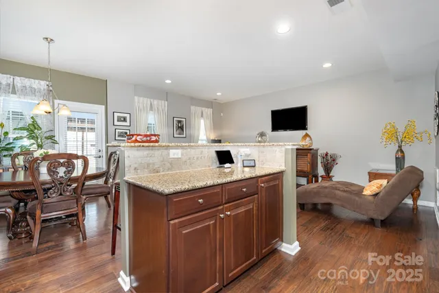 a kitchen with a table chairs refrigerator and a dining table with wooden floor